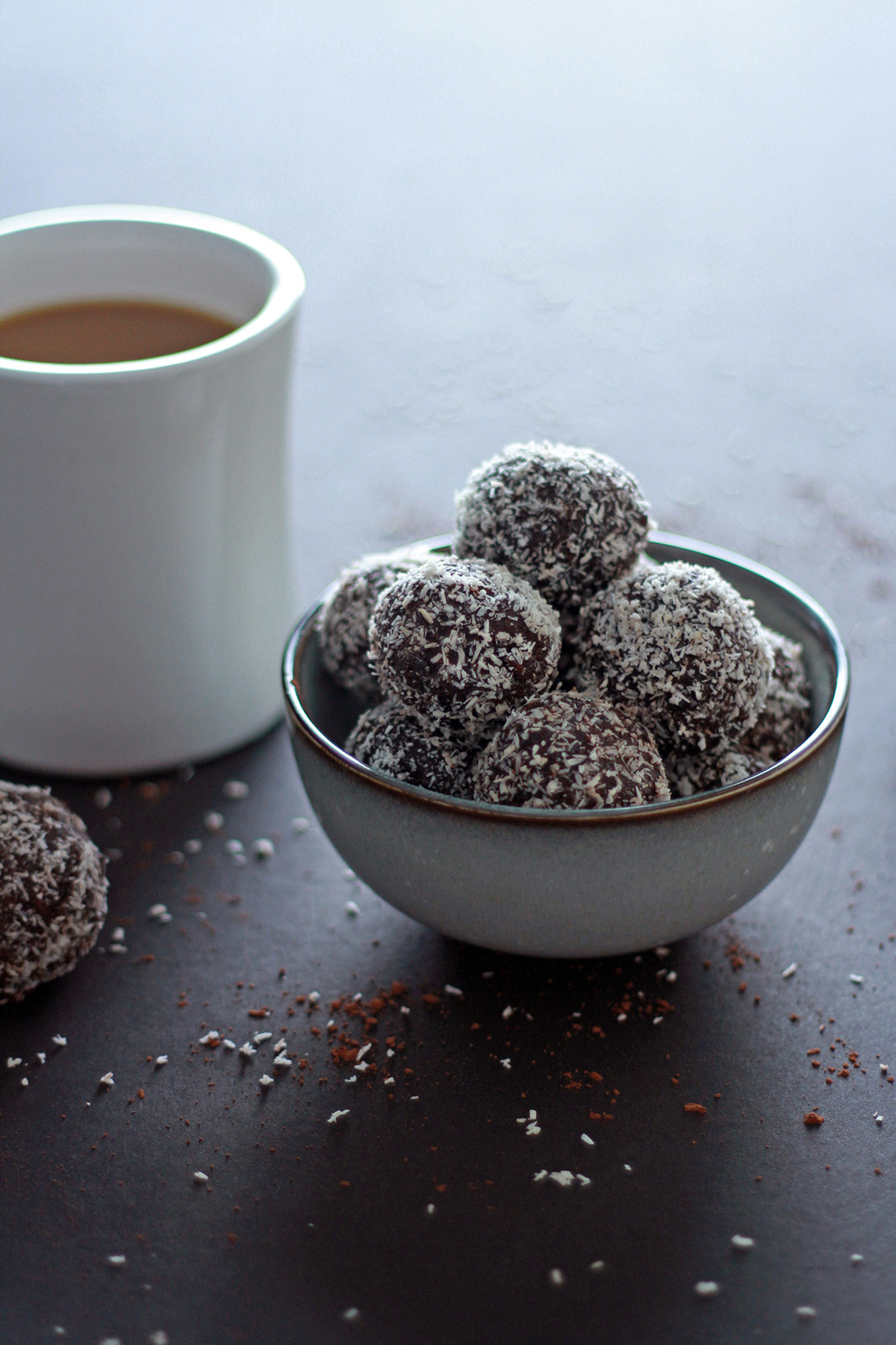 vegan swedish chocolate balls in a bowl with a cup of coffee