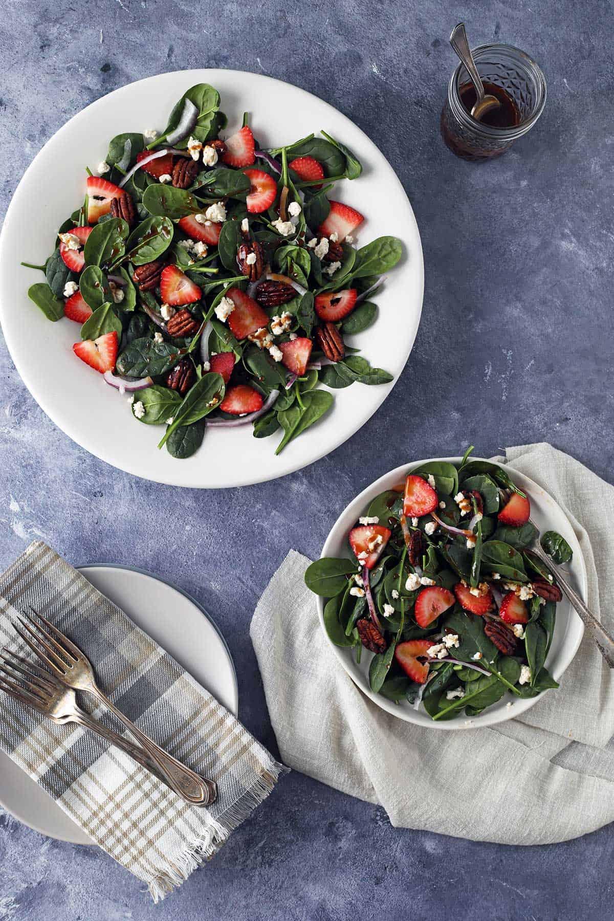 strawberry spinach goat cheese salad in a bowl with dressing
